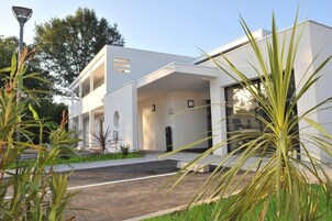 Um edifício moderno, branco, com telhado plano e grandes janelas.