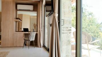 Quarto moderno com escrivaninha, cadeira e grandes janelas.