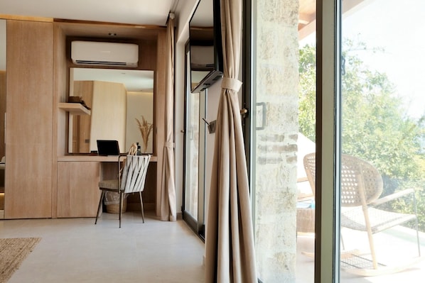 Una habitación moderna con escritorio, silla y ventanas amplias.
