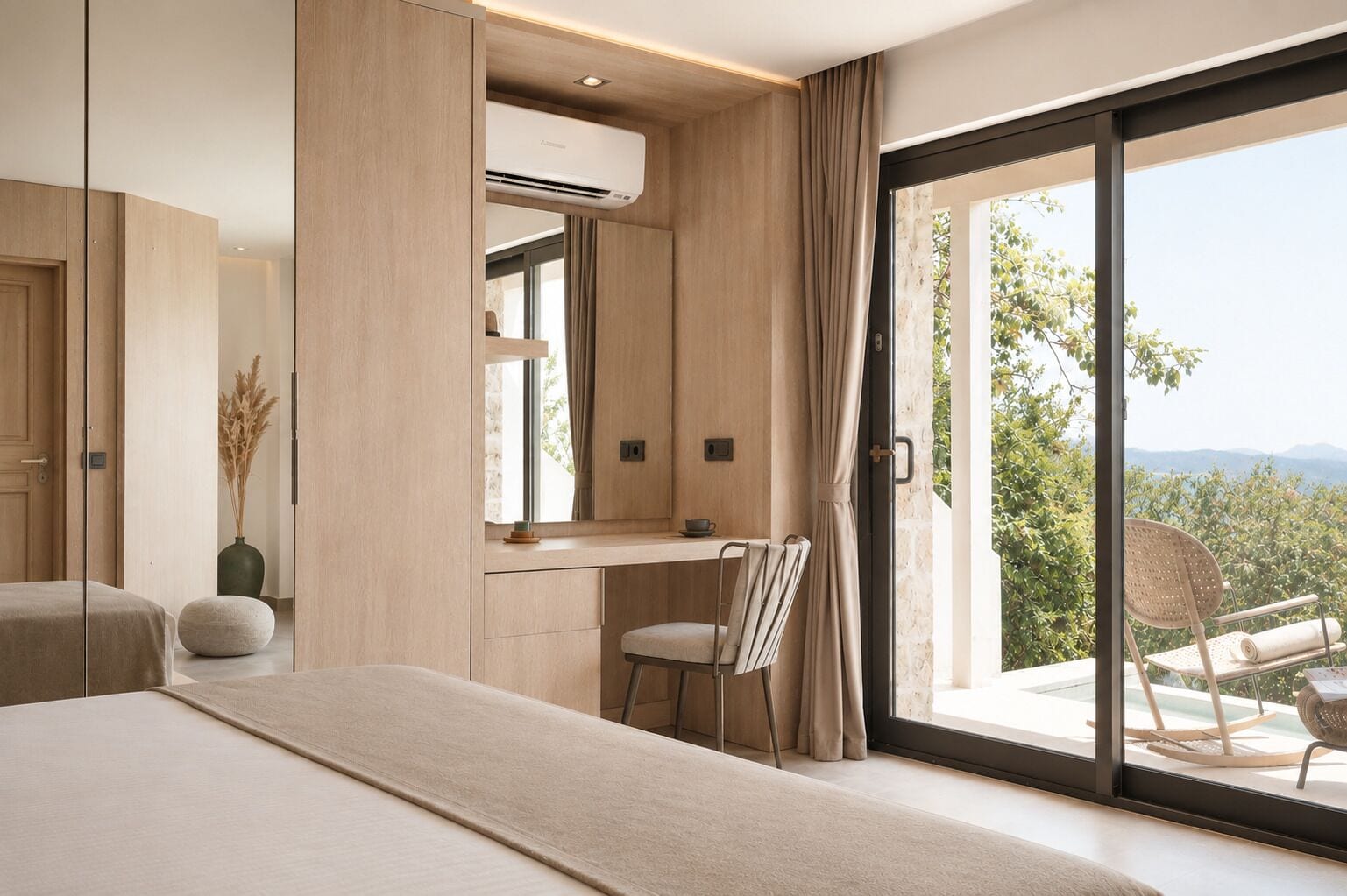 A bedroom with a large bed, a desk, and a view of a balcony with outdoor furniture.
