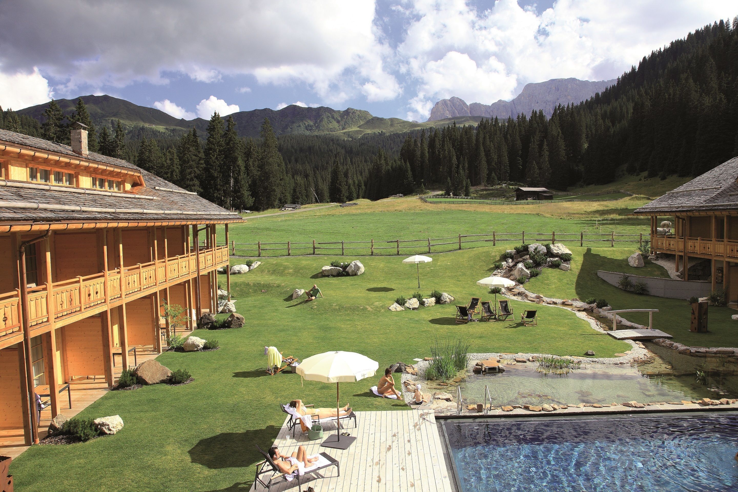 Un resort con piscina, mobiliario exterior y vistas a las montañas.