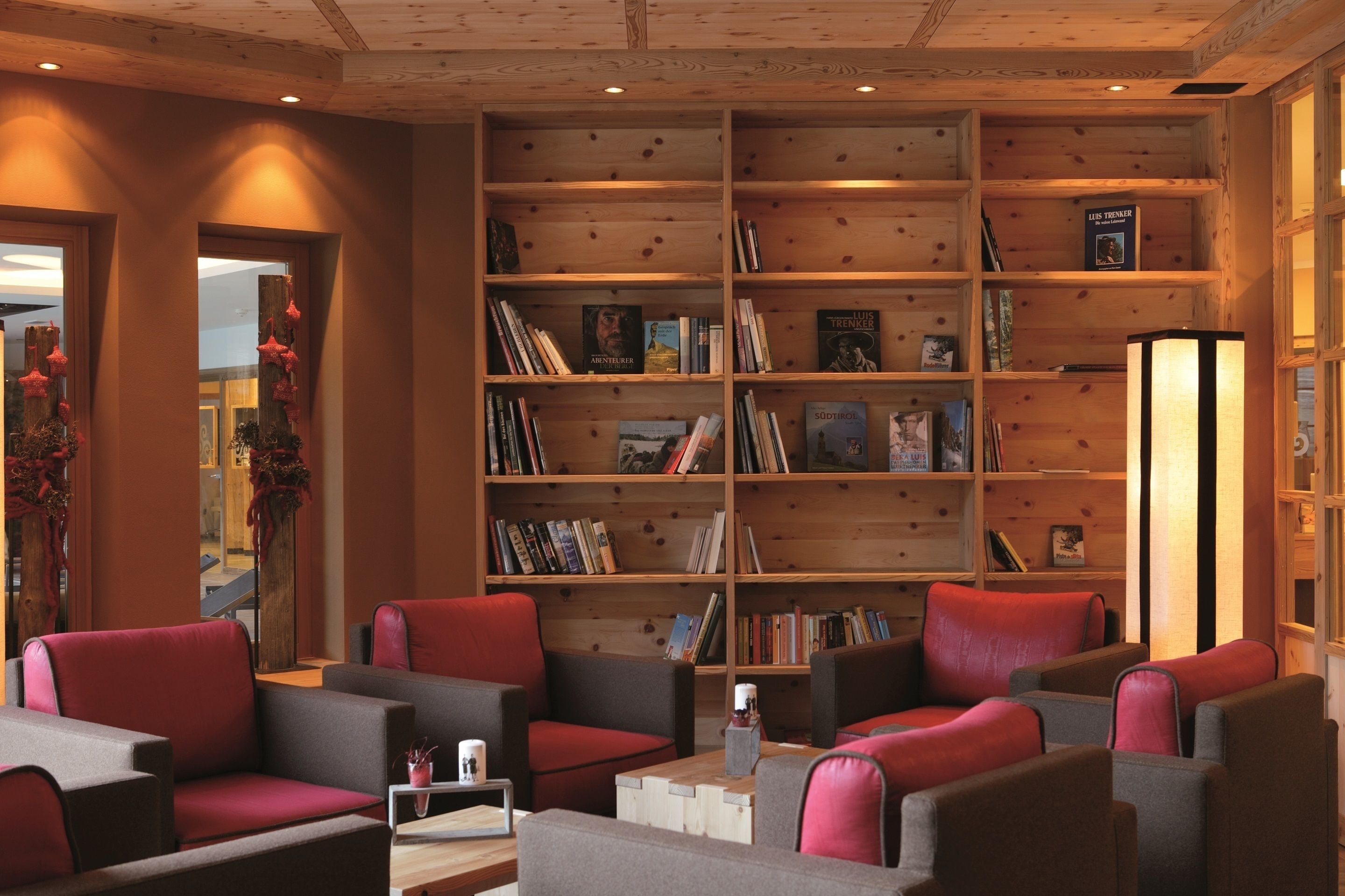 Un rincón acogedor para leer con estanterías, asientos cómodos y un interior de madera cálida.