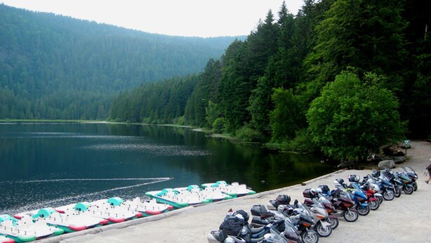 Un área de estacionamiento junto al lago, con barcos y motocicletas.