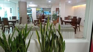 A hotel lobby with a reception desk, seating area, and a large mirror reflecting the space. - Hotel Charthon (Barranquilla)