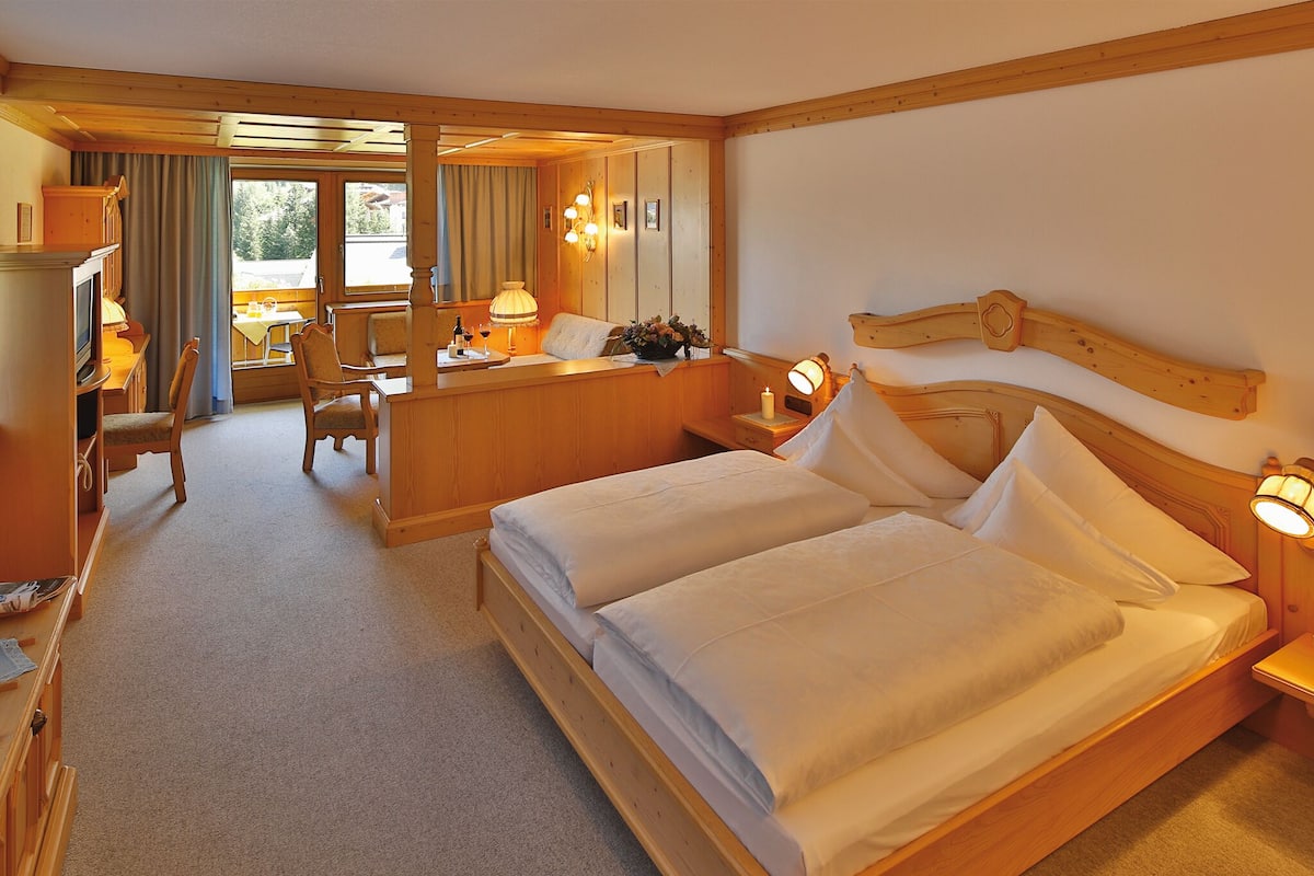 Una habitación de hotel con una cama grande, un escritorio y una silla.
