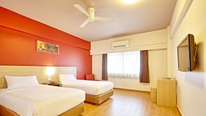 A hotel room with two beds, a ceiling fan, an air conditioning unit, a bedside table with a lamp, and a TV mounted on the wall. - Easy Planet Hat Yai (Hat Yai)