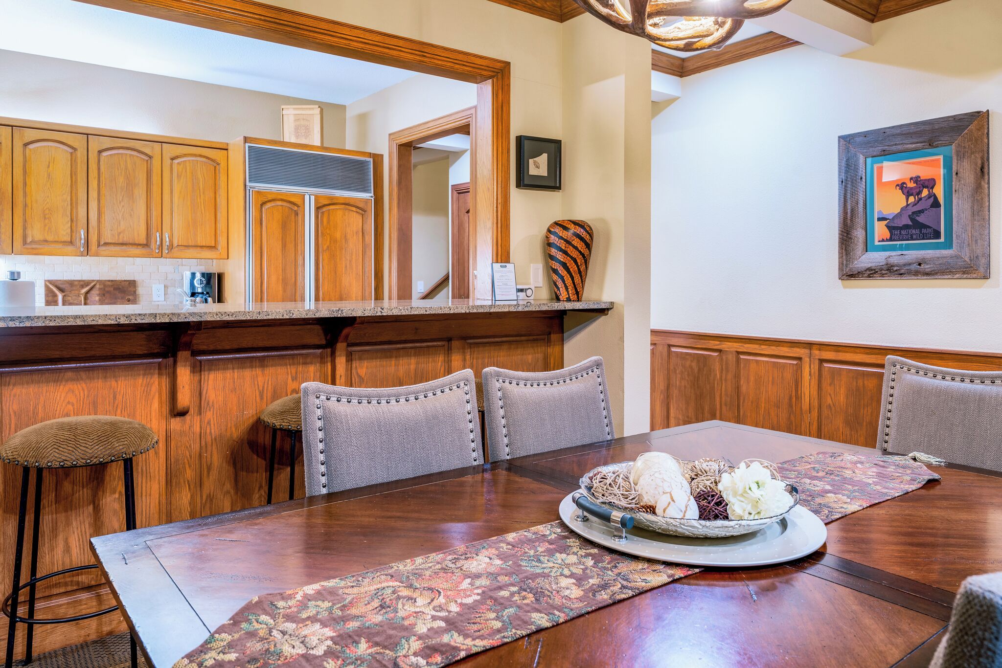 A dining area with a wooden table, six chairs, and a decorative centerpiece.