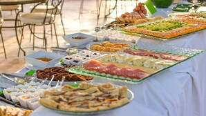 Una mesa de buffet con diversos alimentos, incluyendo carnes, quesos y frutas.
