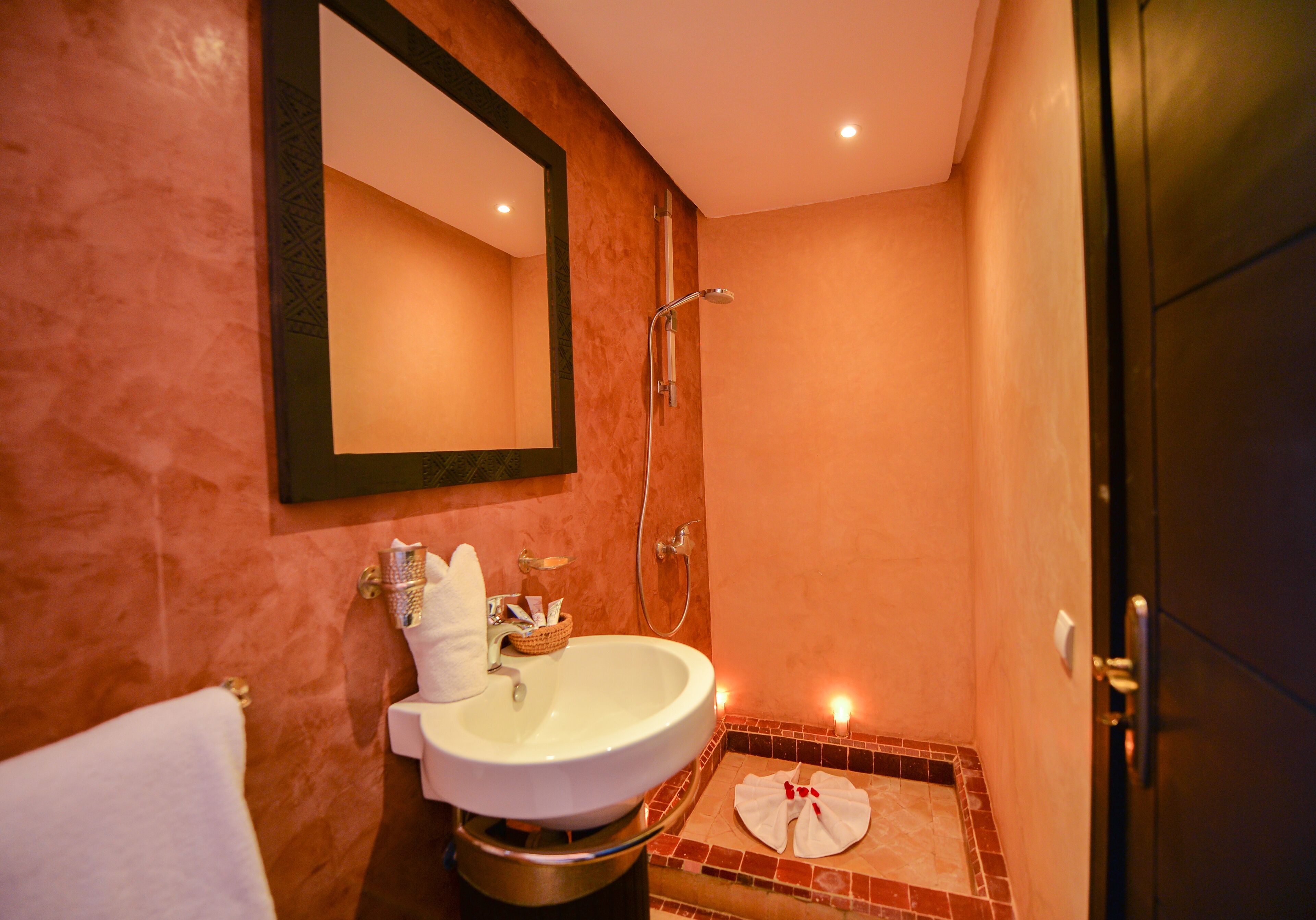 Une salle de bain équipée d’un lavabo, d’un miroir, d’une douche et d’un porte-serviettes.