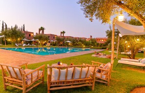 Una piscina al aire libre, sombrillas, tumbonas