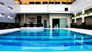 A modern swimming pool with a tiled deck, surrounded by a building with a flat roof and a flat facade. - Manila Grand Opera Hotel (Manila)