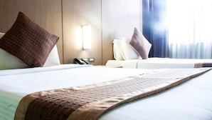 A hotel room with two beds, a nightstand with a phone, and a window with curtains. - Manila Grand Opera Hotel (Manila)