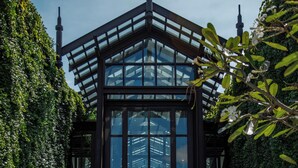 A conservatory with a glass roof, surrounded by potted plants and a checkered floor. - The Siam (Bangkok)