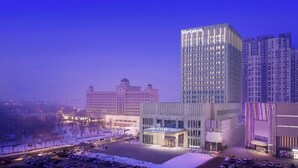 Een hotel met een modern design, met een goed zichtbaar Sheraton bord.
