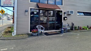 A hotel entrance with a glass door, a signboard advertising amenities like a heated pool and jacuzzi suites, and a number 162 on the door. - Regal Inn (Hampton)