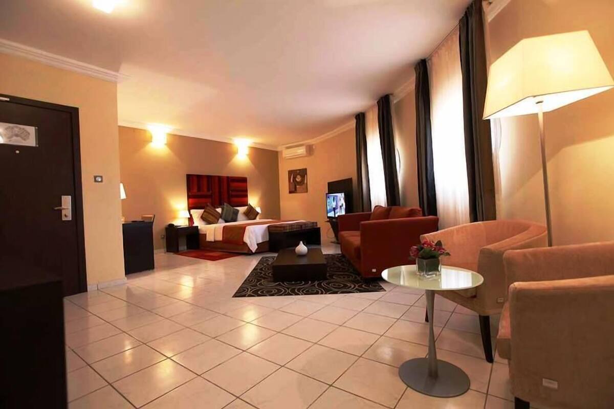 Ein Hotelzimmer mit Bett, einer Couch, einem Couchtisch und einem Fernseher.