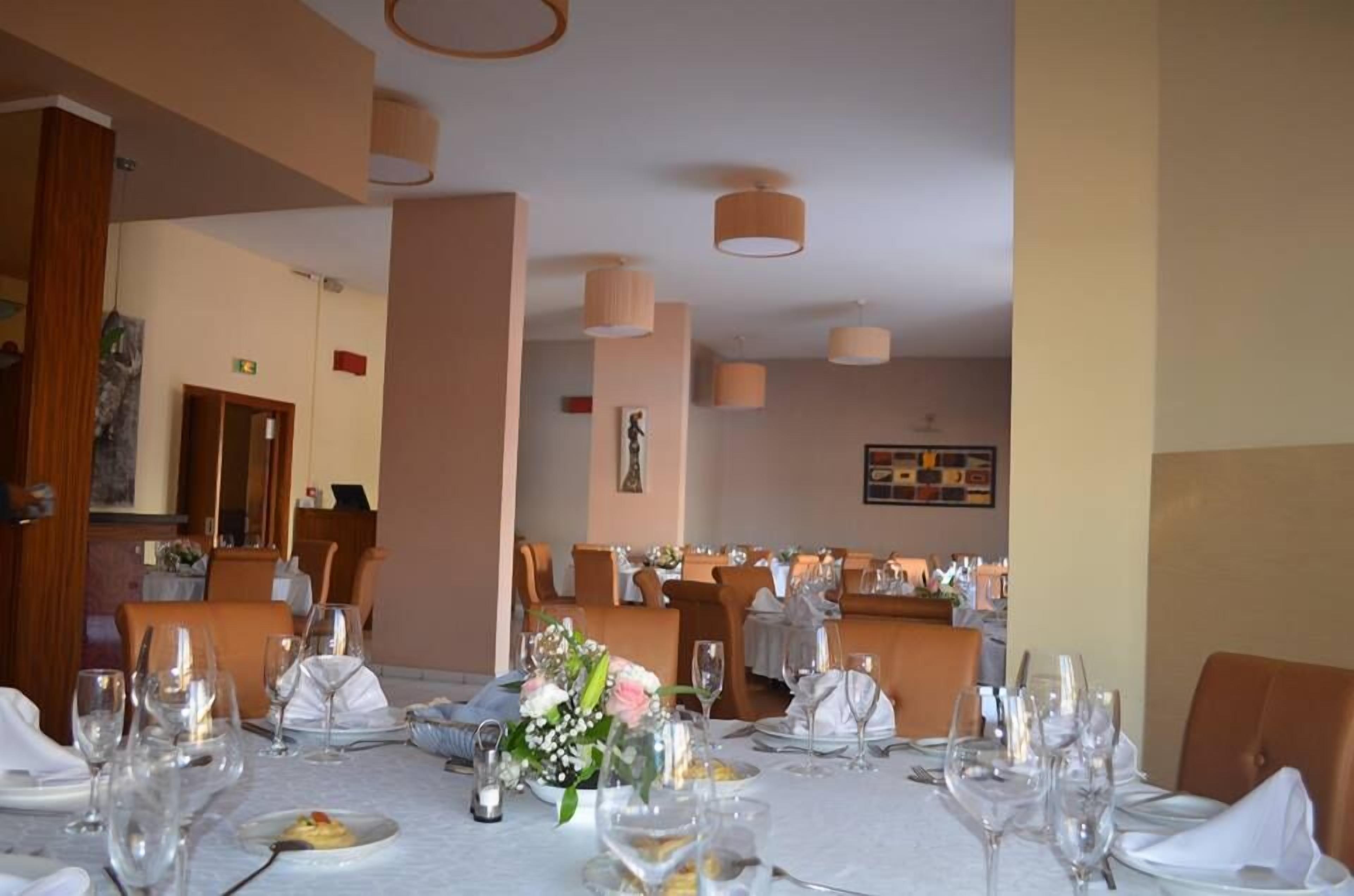 A restaurant with tables set for dining, featuring a neutral color scheme and modern decor.