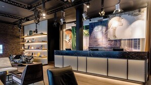 A modern lobby with a reception desk, seating area, and decorative elements. - Motel One Stuttgart-Mitte (Stuttgart)