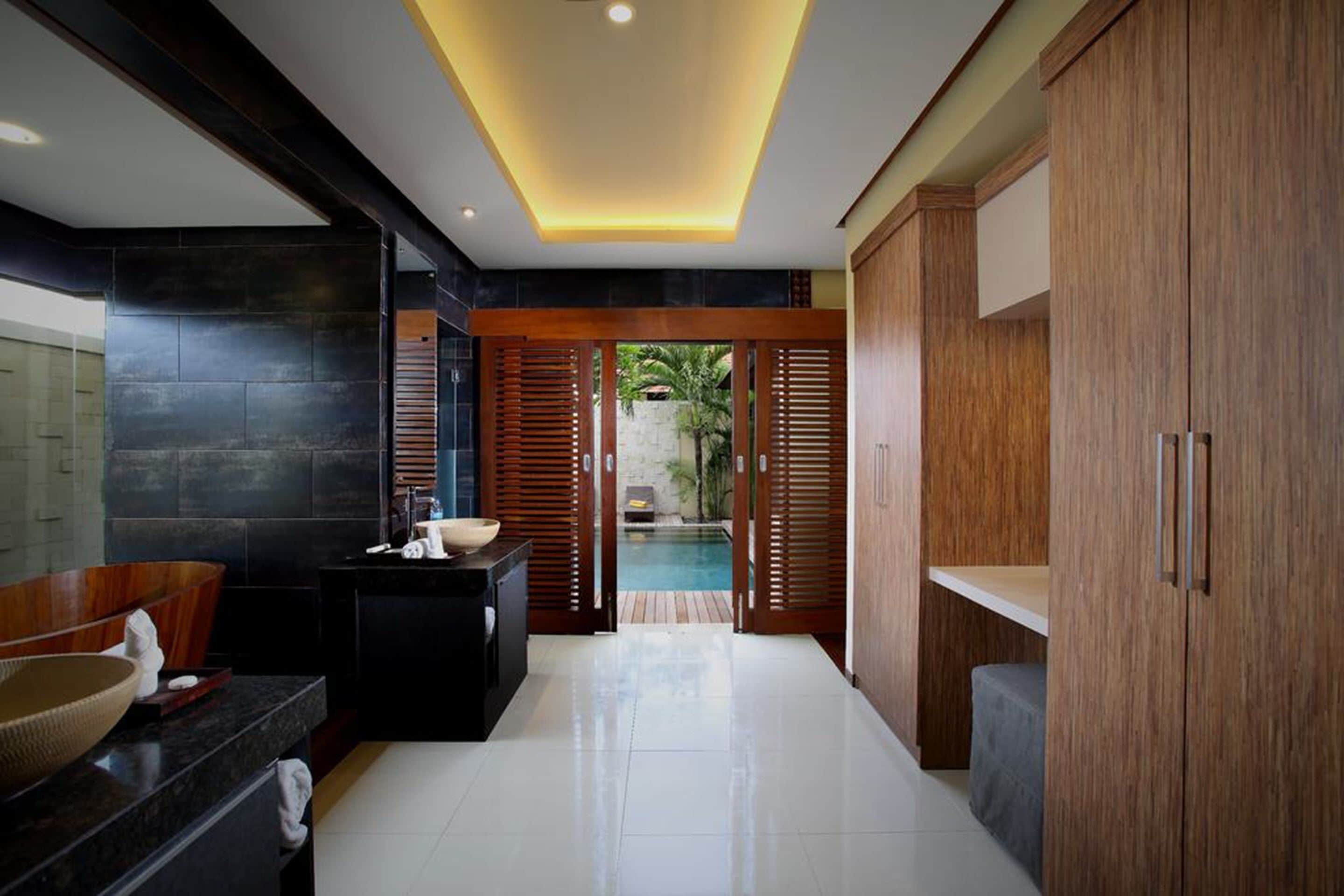 A modern bathroom with a large sink, a mirror, and a wooden cabinet.