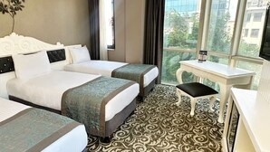 A hotel room with two beds, a desk, and a large window offering a city view. - Taksim Line Hotel (Istanbul)