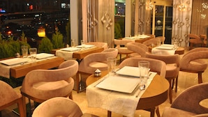 A restaurant with multiple tables and chairs, each set with plates, cutlery, and glasses. - Taksim Line Hotel (Istanbul)