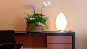 Een bureau met een potplant en een moderne lamp.