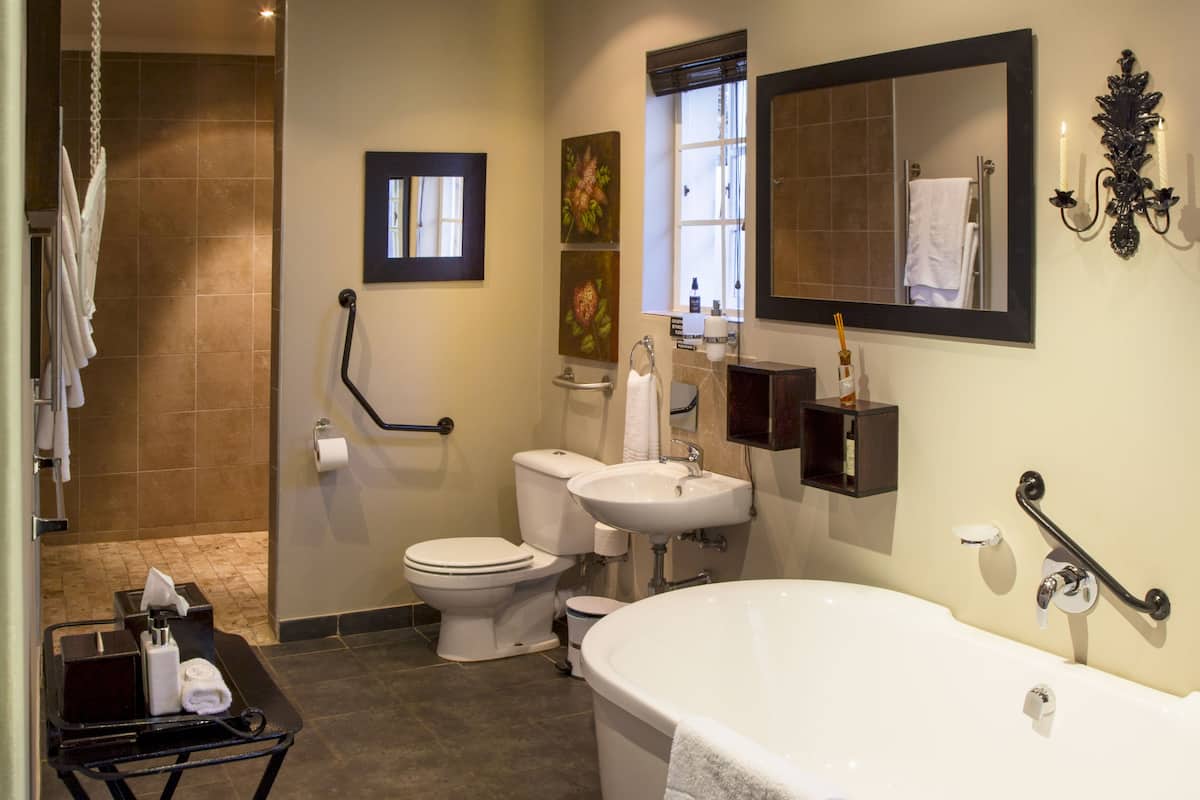 Een moderne badkamer met bad, toilet, wastafel en douche.