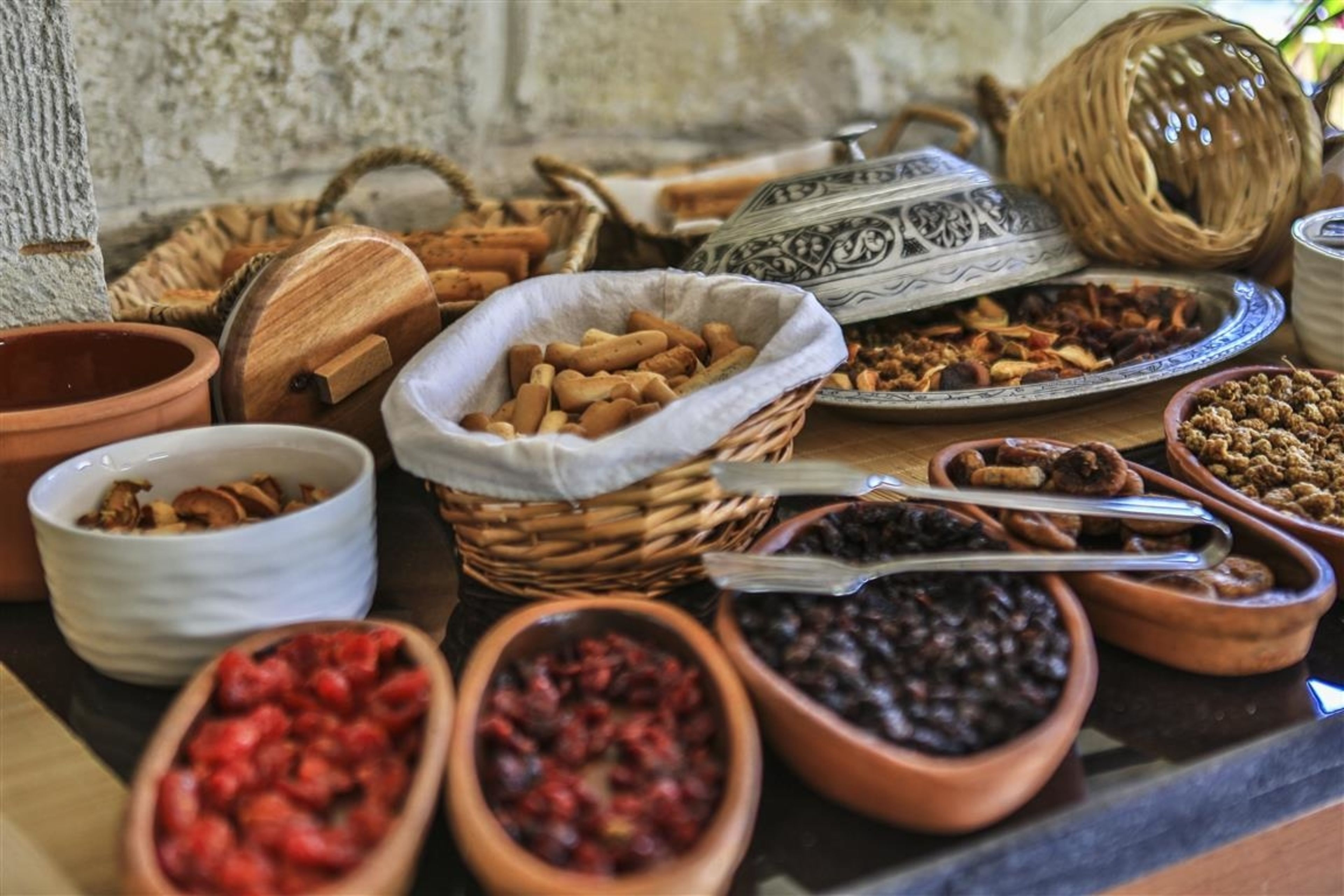 Diversos alimentos expuestos en cuencos y cestas sobre una mesa.