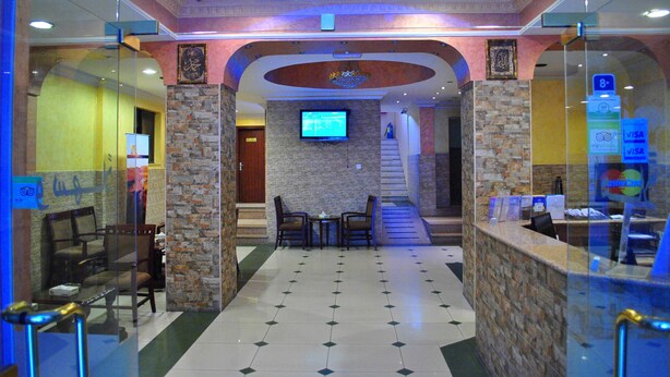 A lobby with a reception desk, seating area, and a TV screen. - Al Qidra Hotel Aqaba (Aqaba)