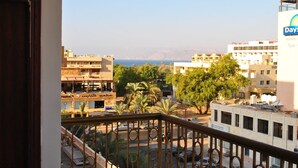 A hotel with a view of the sea, palm trees, and other buildings. - Al Qidra Hotel Aqaba (Aqaba)