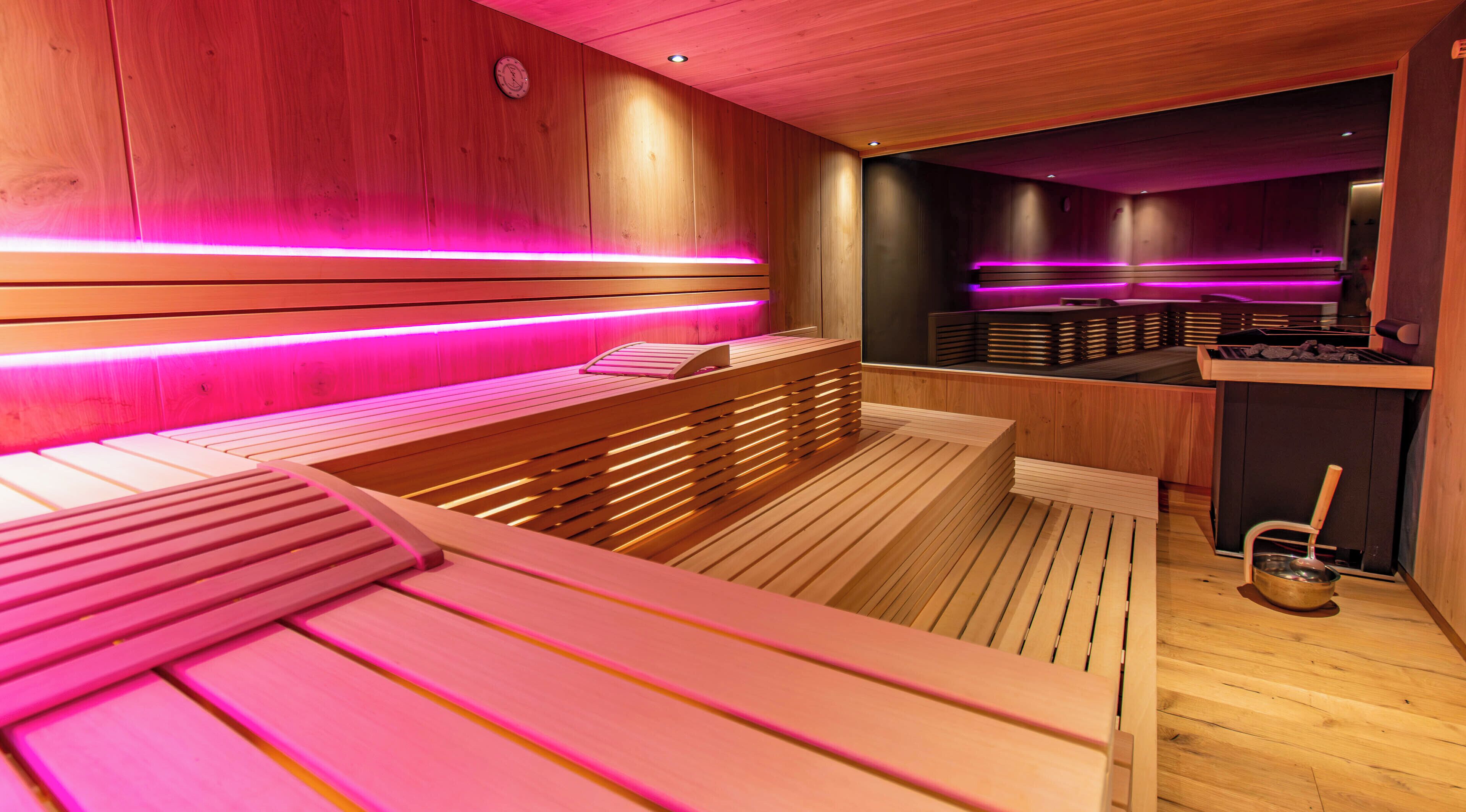 A sauna with wooden benches and benches, wooden walls, and a wooden floor.