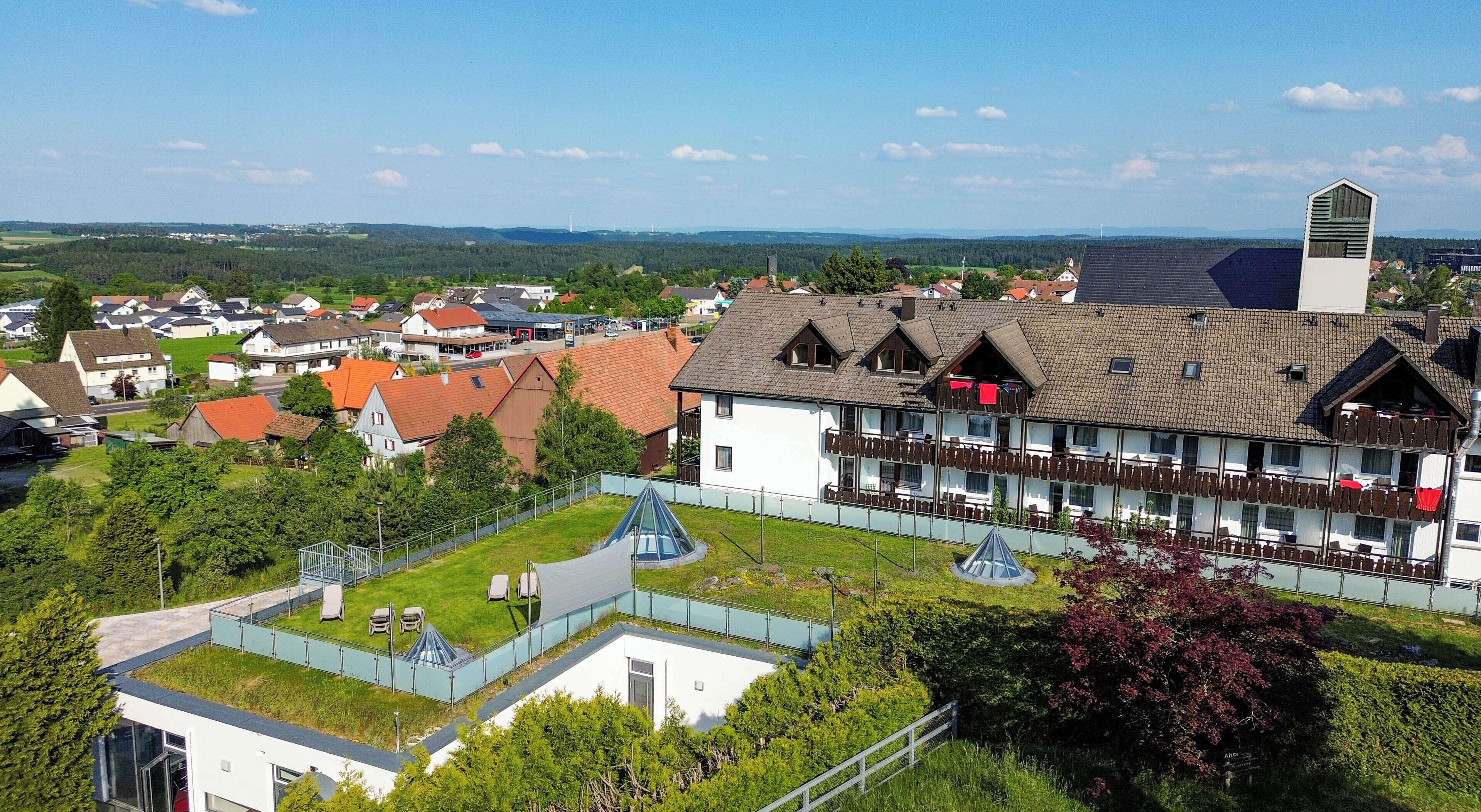 Un hotel de estilo arquitectónico europeo tradicional, con una torre destacada y un patio con zonas de estar.
