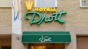 A hotel entrance with a green awning, a sign reading "HOTEL Droit", and a number "19" on the building facade. - Hotell Drott (Norrköping)