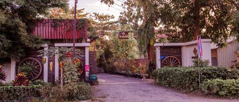 A rustic entrance with a wooden fence, a large wheel, and a sign indicating a sanctuary.