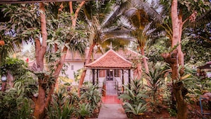 A covered pavilion with a tiled roof, surrounded by lush tropical plants and trees. - The Sanctuary Villa Battambang (Battambang)