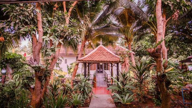 A covered pavilion with a tiled roof, surrounded by lush tropical plants and trees. - The Sanctuary Villa Battambang (Battambang)