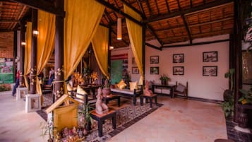 A traditional interior with a thatched roof, wooden furniture, and decorative items.
