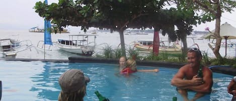 A pool area with boats and a beach in the background.