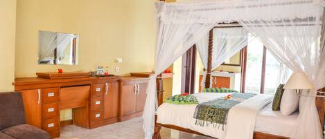 A room with a bed, a wooden desk, a chair, a mirror, and a window.
