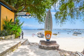 Un panneau indiquant l’accès à la plage de Tamarind, avec vue sur des bateaux et une plage de sable.