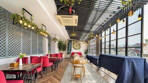 A restaurant with red chairs, tables, and a patterned floor. - Sabina Residence - Stellar Boutique Hotel (Ho Chi Minh City)