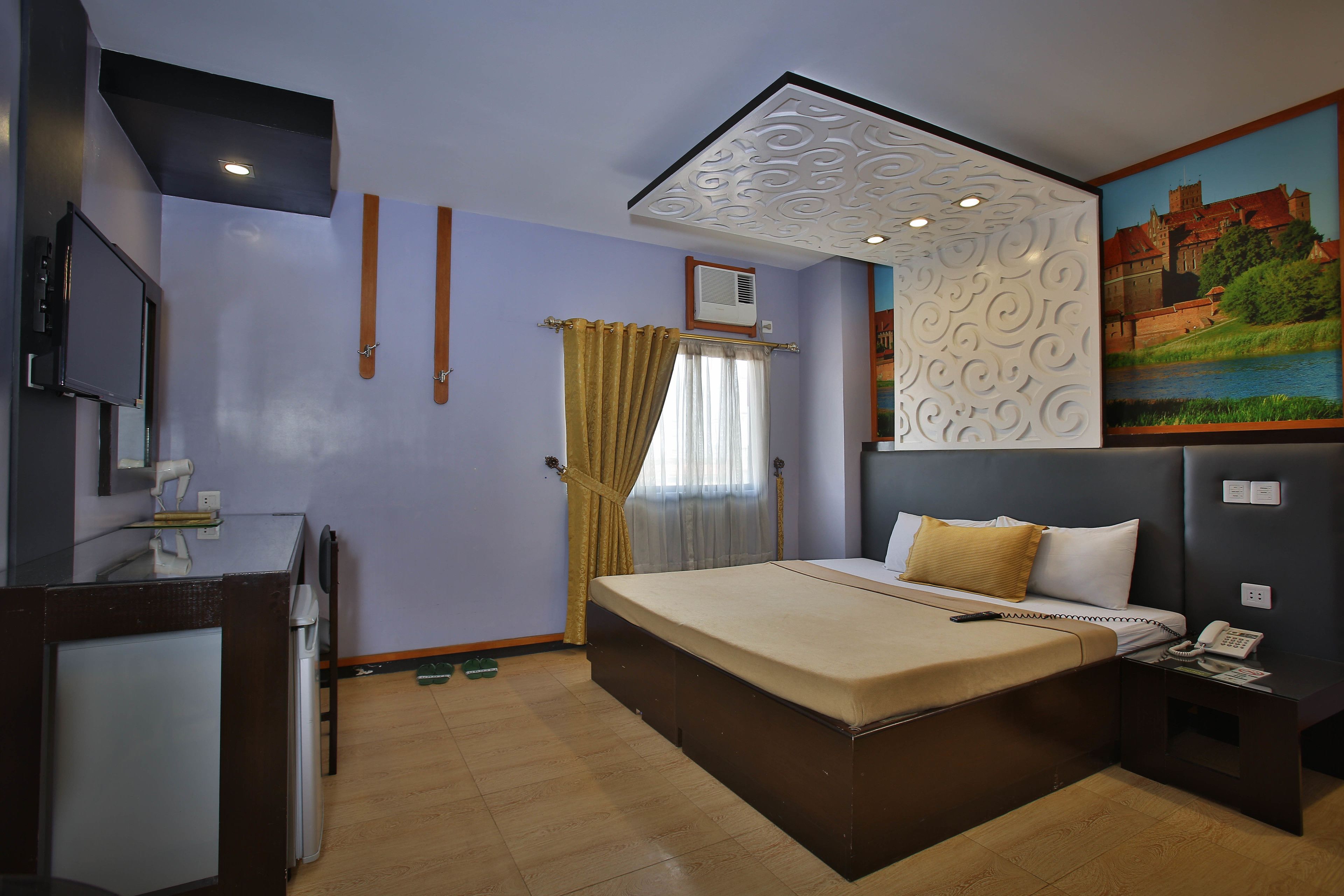 Ein Hotelzimmer mit Bett, Nachttisch und einem Gemälde an der Wand.