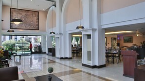 Un hall d’entrée spacieux, doté de hauts plafonds, de grandes fenêtres et d’un espace salon central.