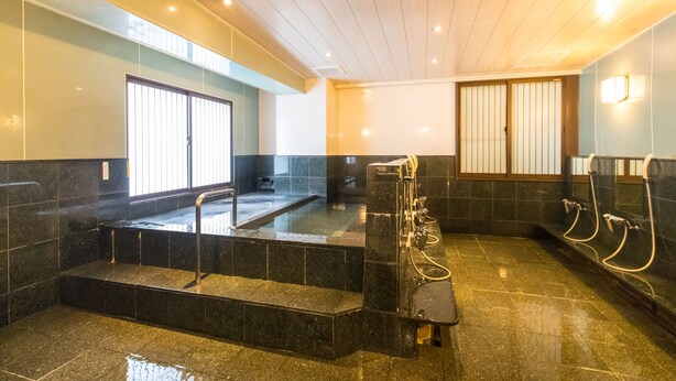 Un baño moderno con una bañera grande, zona de ducha y retrete.