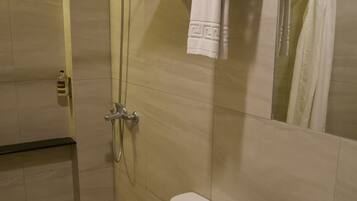 Un baño moderno con inodoro, lavamanos y ducha.