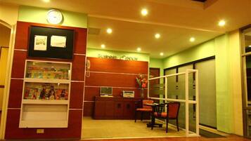 A reception area with a desk, chairs, a clock, and framed certificates on the wall.