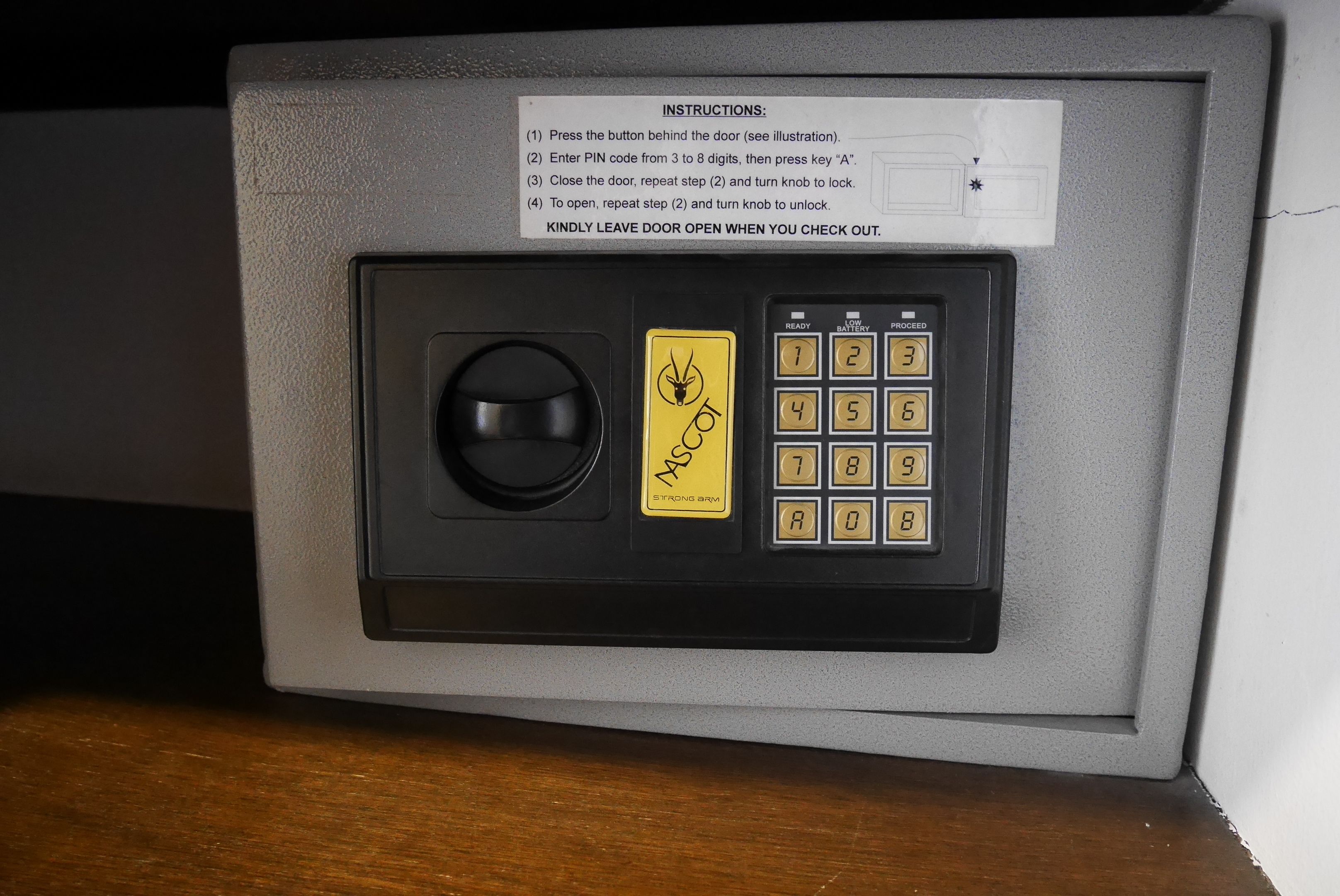 A safe with a keypad and a lock mechanism, accompanied by instructions for use.