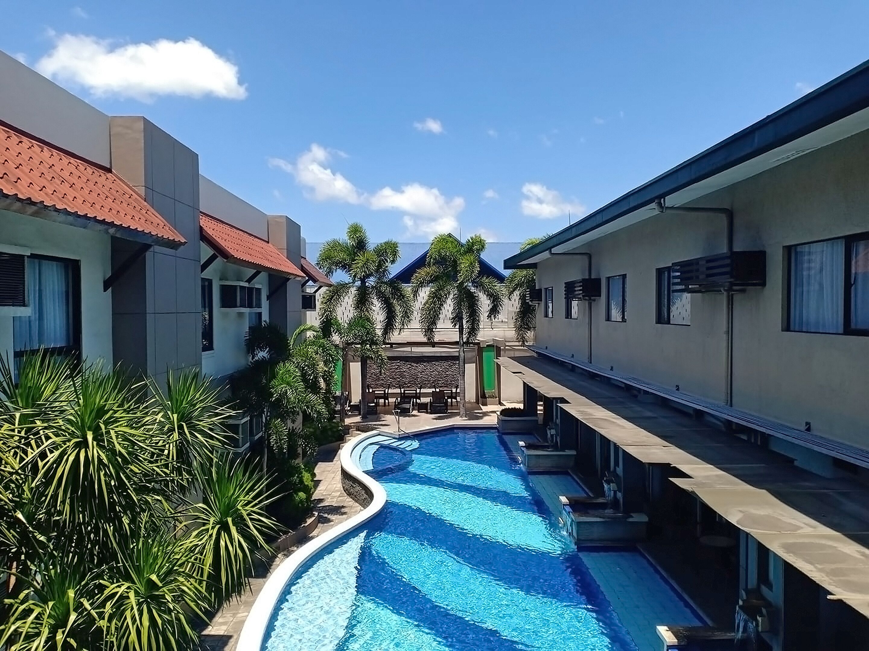 A swimming pool surrounded by modern buildings with a clear sky above.