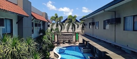 A swimming pool surrounded by modern buildings with a clear sky above.