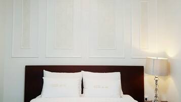 Una habitación de hotel con una cama grande, una mesita de noche, una lámpara y una luz en el techo.